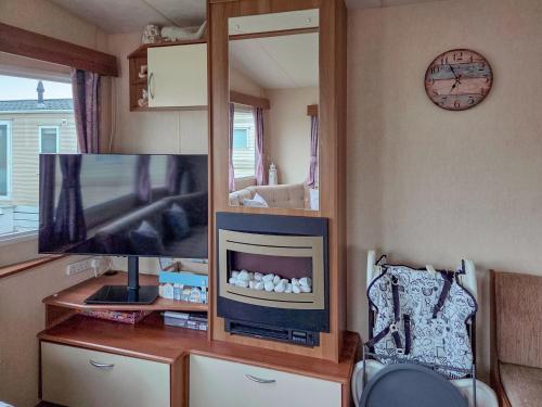a living room with a tv and a mirror at Waterlily in Lancaster
