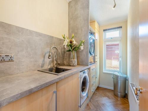 a kitchen with a sink and a washing machine at Willowbank Lodge in Stratford-upon-Avon