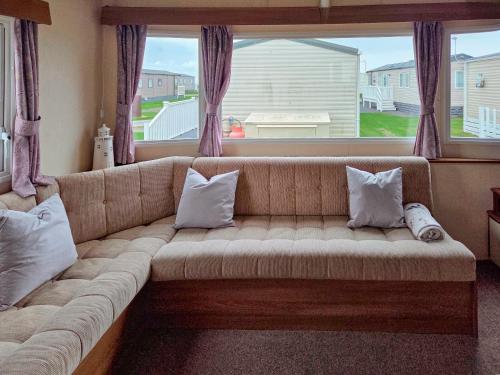 a couch in a living room with a large window at Waterlily in Lancaster