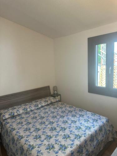 una camera da letto con un letto con copriletto floreale blu di Villa Dea a Quartu Sant'Elena