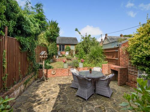 a patio with a table and chairs in a backyard at Foresters Rest in Selborne
