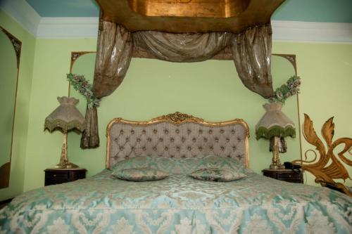 a bedroom with a bed with a canopy and two lamps at Pensiunea Paradis in Râmnicu Vâlcea