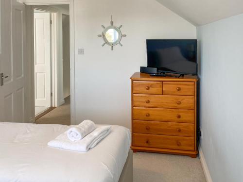 een slaapkamer met een bed en een dressoir met een televisie bij Chy An Mordros in Hayle