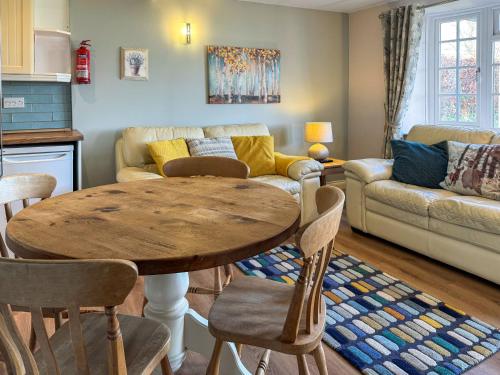 ein Wohnzimmer mit Tisch und Couch in der Unterkunft Primrose Cottage - Uk49219 in Burythorpe