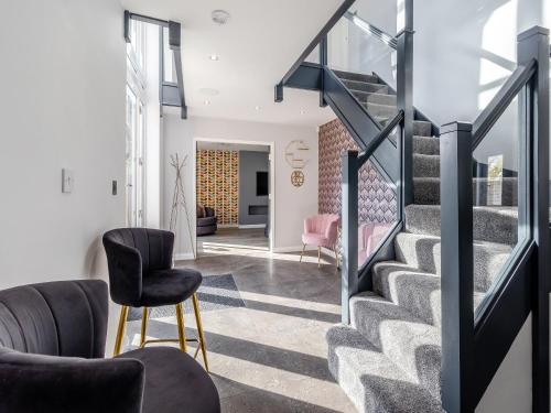 a living room with stairs and chairs at The Old School House in Barnsley