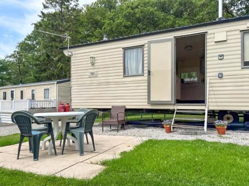 a patio with a table and chairs and a caravan at Swaledale 5 in Tosside