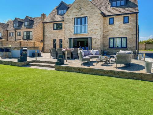 a house with a patio and lawn in front of it at The Old School House in Barnsley