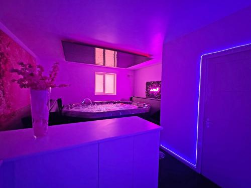 a purple bathroom with a tub and a vase with flowers at The Old School House in Barnsley