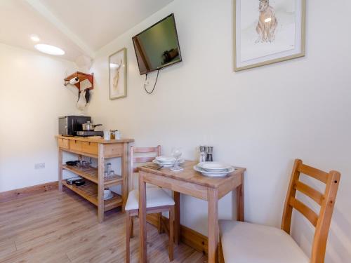 a dining room with a table and a tv at Beinn Uidhe Studio Apartment - Uk49100 in Inchnadamph