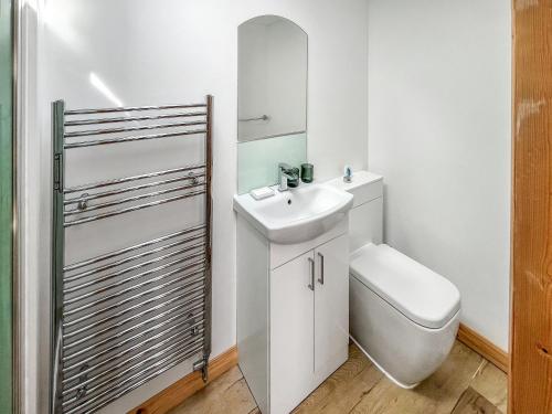 a white bathroom with a toilet and a sink at Parade - Uk49713 in Greatstone