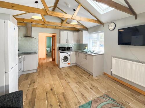 a kitchen with white cabinets and a washer and dryer at Parade - Uk49713 in Greatstone