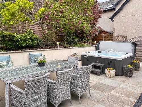 a patio with a table and a hot tub at Autumn Leaves in Keswick