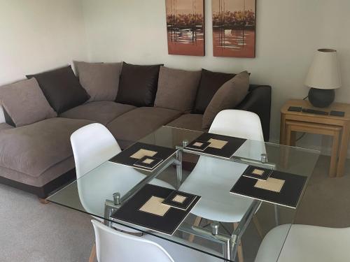 ein Wohnzimmer mit einer Couch und einem Glastisch in der Unterkunft Hawthorn Apartment - Uk49283 in Woolfardisworthy