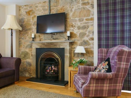 uma sala de estar com duas cadeiras e uma lareira em Roslin Chapel Cottage - Uk49193 em Roslin