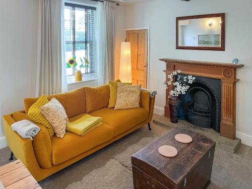 a living room with a couch and a fireplace at Wisteria Cottage in Harrogate