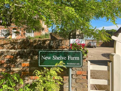 a new shingle farm sign in front of a brick wall at The Oast - Uk49207 in Lenham
