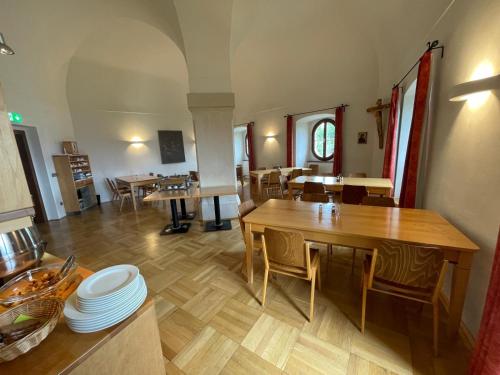 a dining room with wooden tables and chairs at Gästehaus Benediktinerstift Göttweig - Bed & Breakfast Monastery in Furth