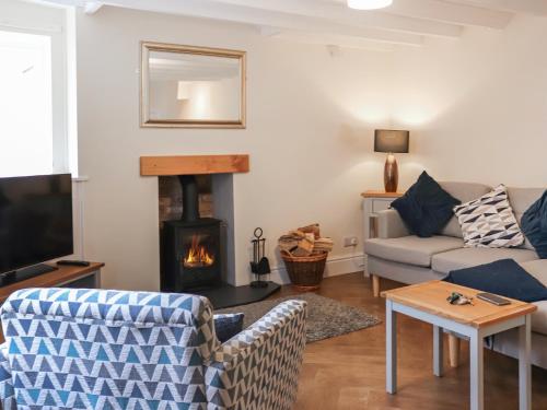 a living room with a couch and a fire place at Ty Llewelyn in Conwy