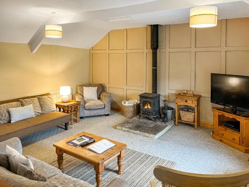 a living room with a fireplace and a tv at 4 Swallowholm Cottage in Richmond