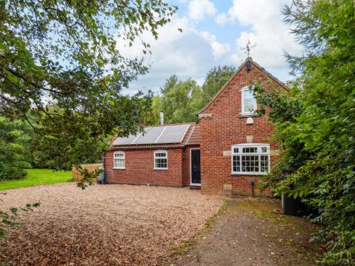 an old brick house with a large driveway at Paws In The Pines in Frithville