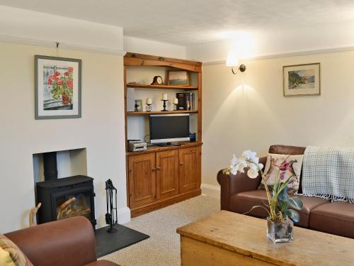 ein Wohnzimmer mit Sofa und Kamin in der Unterkunft Penhill Farm Cottage in Fremington