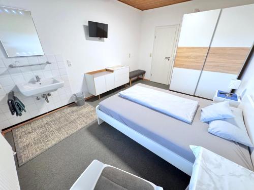 ランダウ・アン・デア・イザールにあるApartmenthaus Wohnbau GmbH Gebrüder Laurentの大きなベッドと洗面台のある寝室