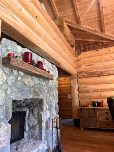 a stone fireplace in a log cabin with wooden ceilings at RaxChalet in Prein