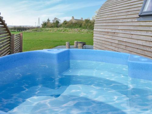 a large blue swimming pool next to a house at Husk - Uk49321 in Lowthorpe
