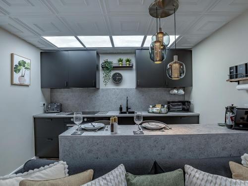 a kitchen with black cabinets and a counter with wine glasses at The Old Post Office - Uk49450 in Haltwhistle