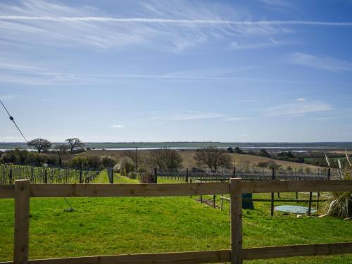 a wooden fence with a view of a field at Periwinkle No5 - Uk49249 in Althorne