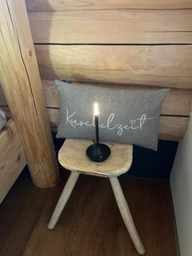 a candle sitting on a small table with a pillow at RaxChalet in Prein