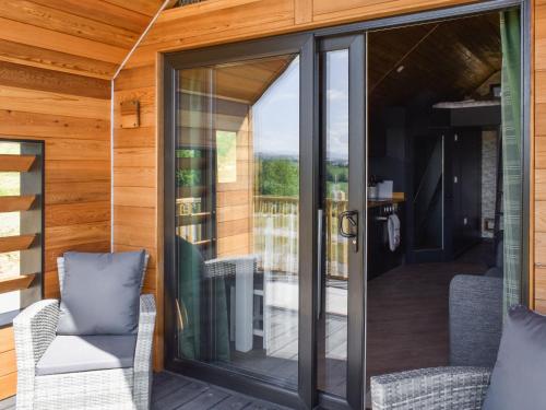 a screened in porch with glass doors and chairs at Yan - Uk49355 in Gatebeck