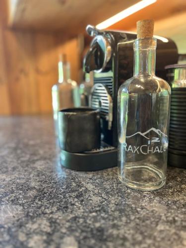 a glass bottle sitting on a counter next to a toaster at RaxChalet in Prein