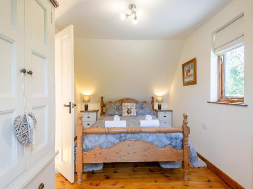 a bedroom with a wooden bed in a room at Cedar - Uk49525 in Saint Lawrence