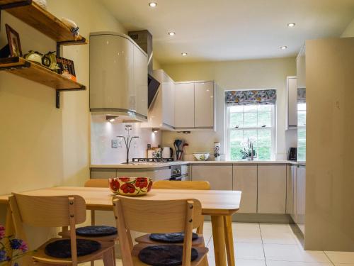 a kitchen with a wooden table and chairs at The Mount View in Towcester