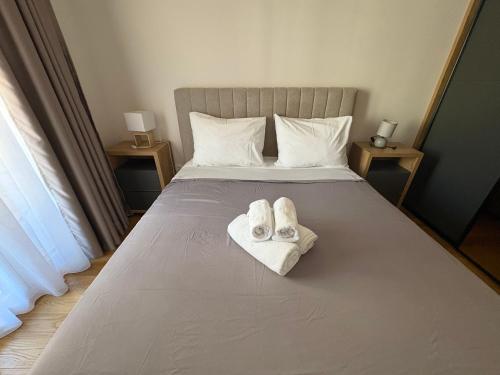a bed with two pairs of shoes sitting on it at Apartments Central Point 11 & Private Garage in Podgorica