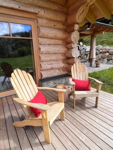 two chairs sitting on a porch of a log cabin at RaxChalet in Prein