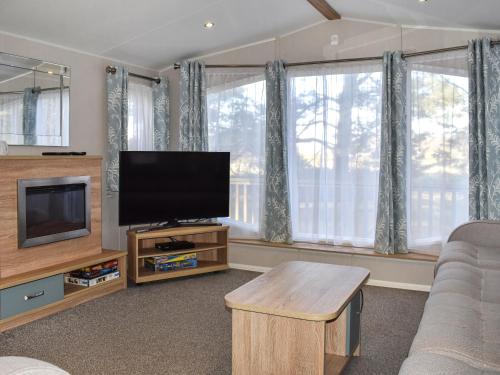 a living room with a flat screen tv and a couch at Unit 44 in Weybourne