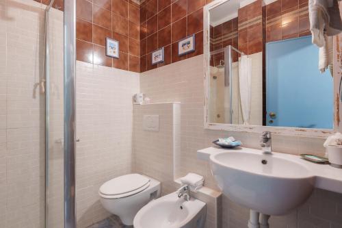a white bathroom with a sink and a toilet at Hotel Sant'Andrea in Marciana