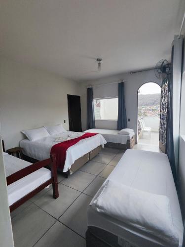 a hotel room with two beds and a window at Pousada Sinhá Moça in Diamantina