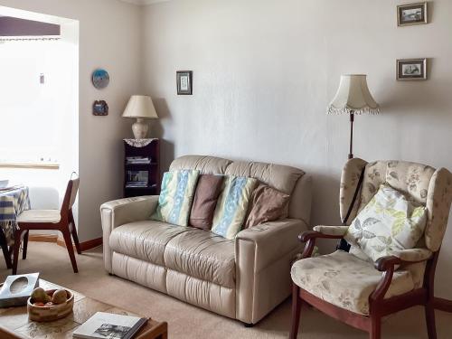 a living room with a couch and a chair at Cosy Cottage By The Sea in Cromarty