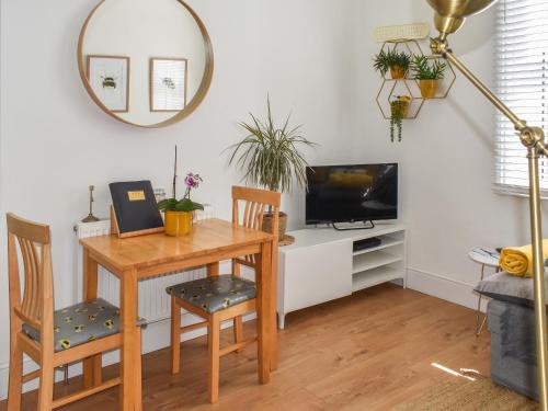 a dining room with a table and a tv at Trinity Bee in Ventnor