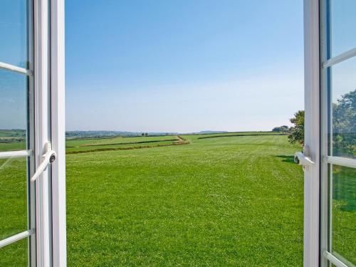 an open window with a view of a green field at Greenfinch Apartment - Uk49310 in Woolfardisworthy