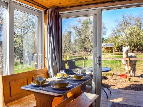 a room with a table and a view of a dog at Alpaca Lodge in Acton