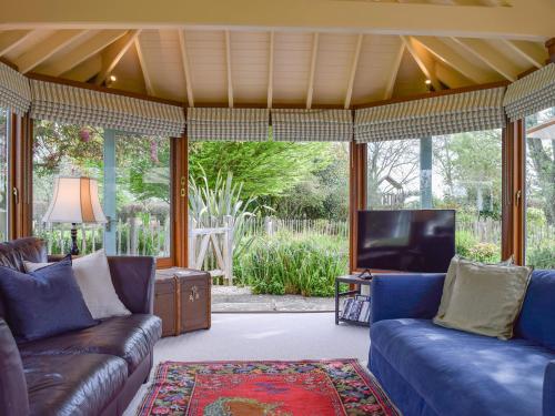 un salon avec des canapés et une télévision à écran plat dans l'établissement Lomond Cottage, à Garsington