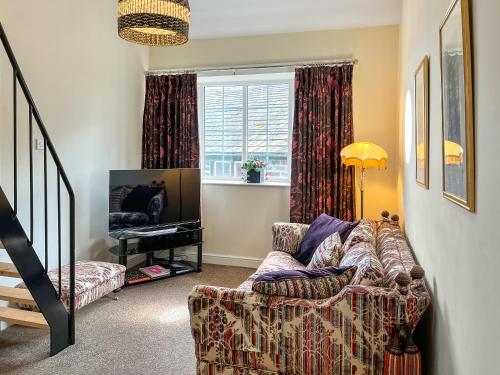 a living room with a couch and a television at Bank Top Mews - Uk49214 in Wilsden