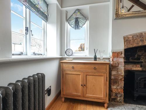 un salon avec un radiateur et une cheminée dans l'établissement Blossom Cottage, à Lydney