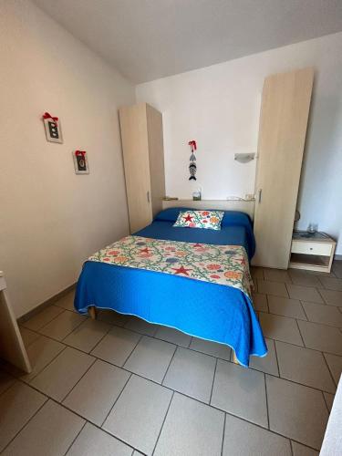 a bedroom with a bed with a blue bedspread at Hotel Sant'Andrea in Marciana
