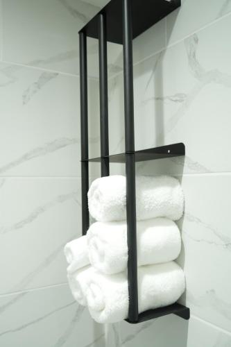 a stack of towels on a shelf in a bathroom at Concept Rooms 6 Central Enfield Town Station in Enfield