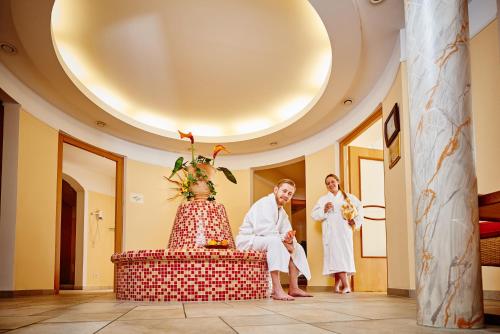 a bride and groom standing in a room with a cake at AKZENT Hotel Bayerwald-Residenz in Neukirchen